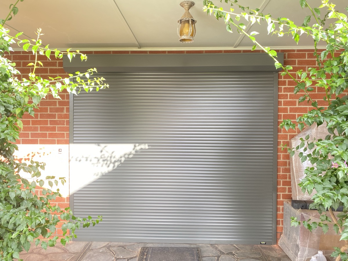 Grey roller shutter with greenery