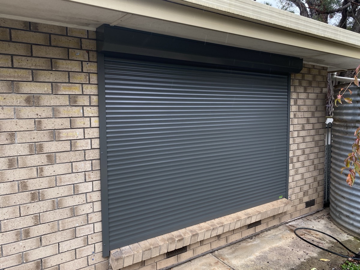 Charcoal roller shutter on brick