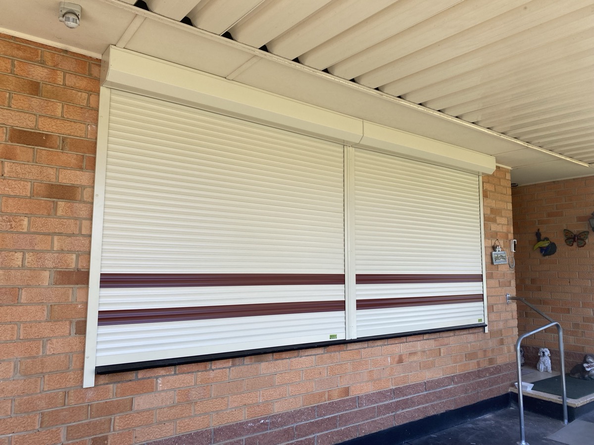 Cream roller shutters brick home