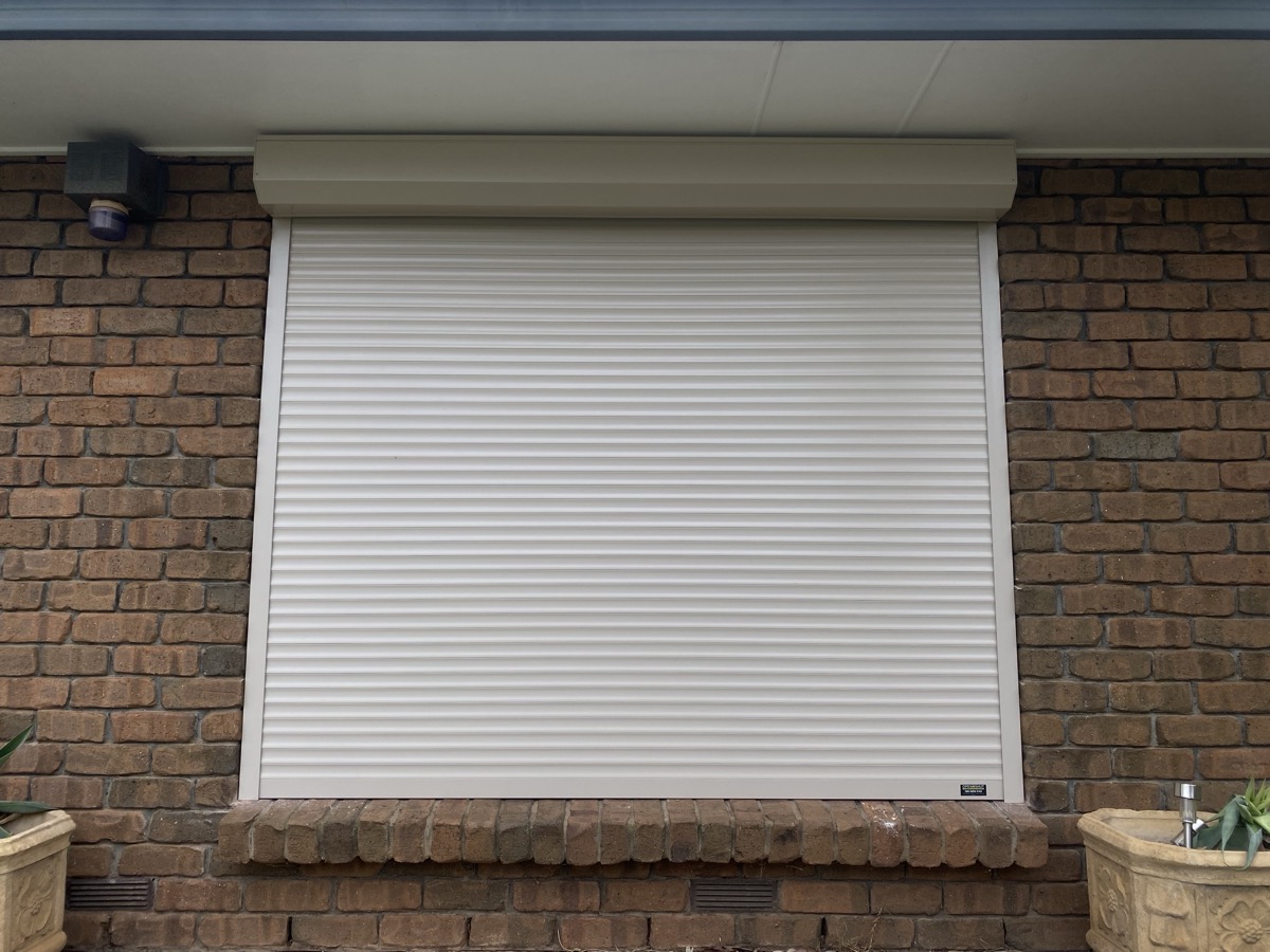 White roller shutter on brick wall